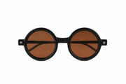 Minimalist round sunglasses with a matte black frame and warm brown lense